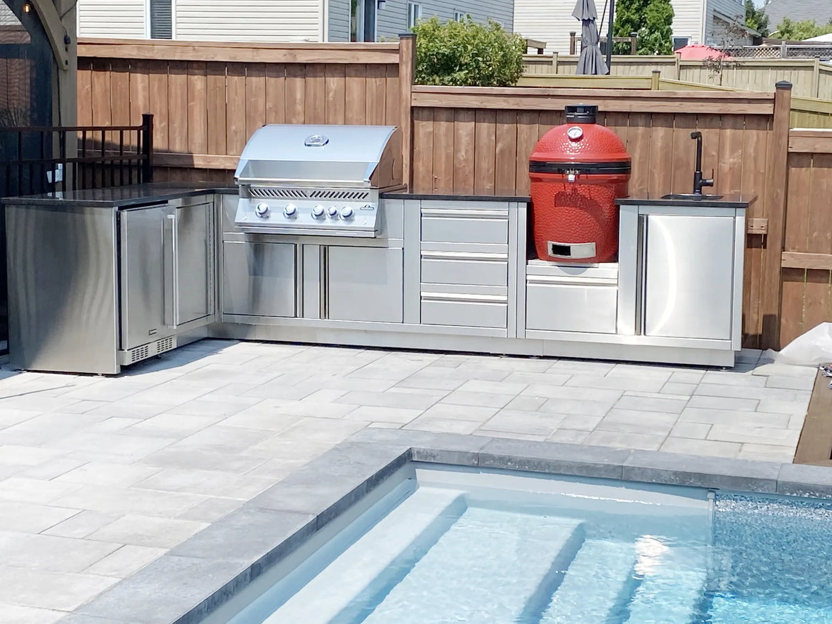 Cuisine extérieure Cuinox en inox avec kamado rouge au bord de la piscine