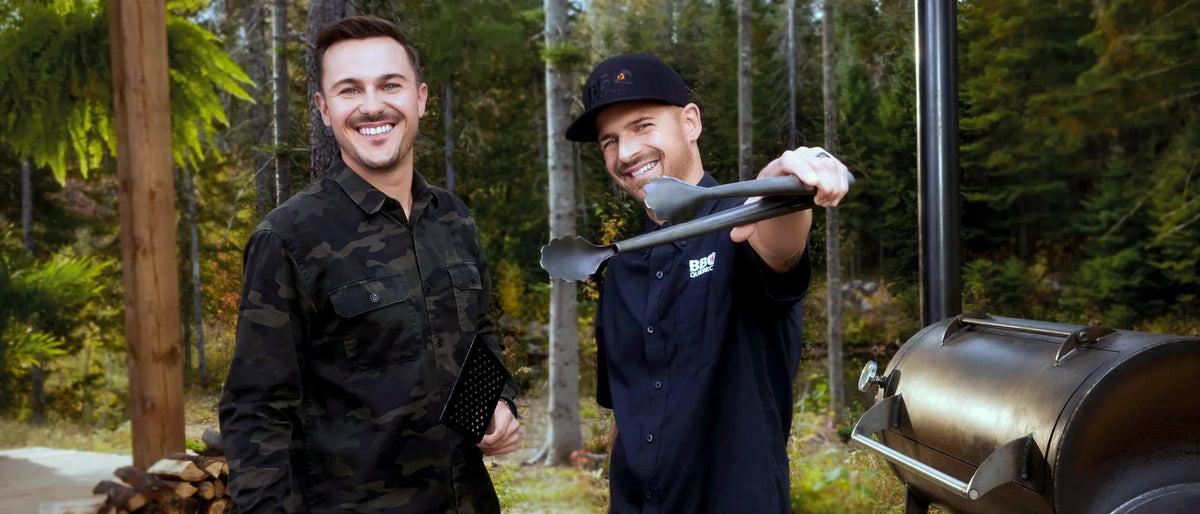 Max et Jean-Philippe Lavoie devant un fumoir, en forêt d'automne